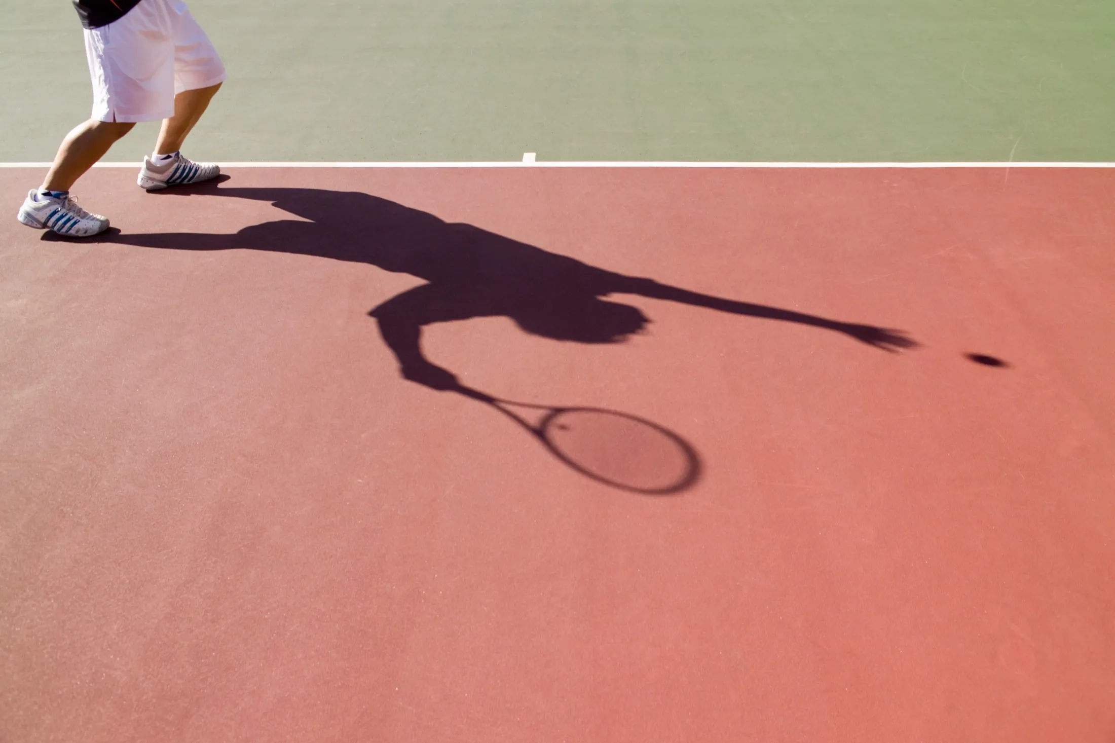 Schlagschatten eines Aufschlags auf dem Tennisplatz