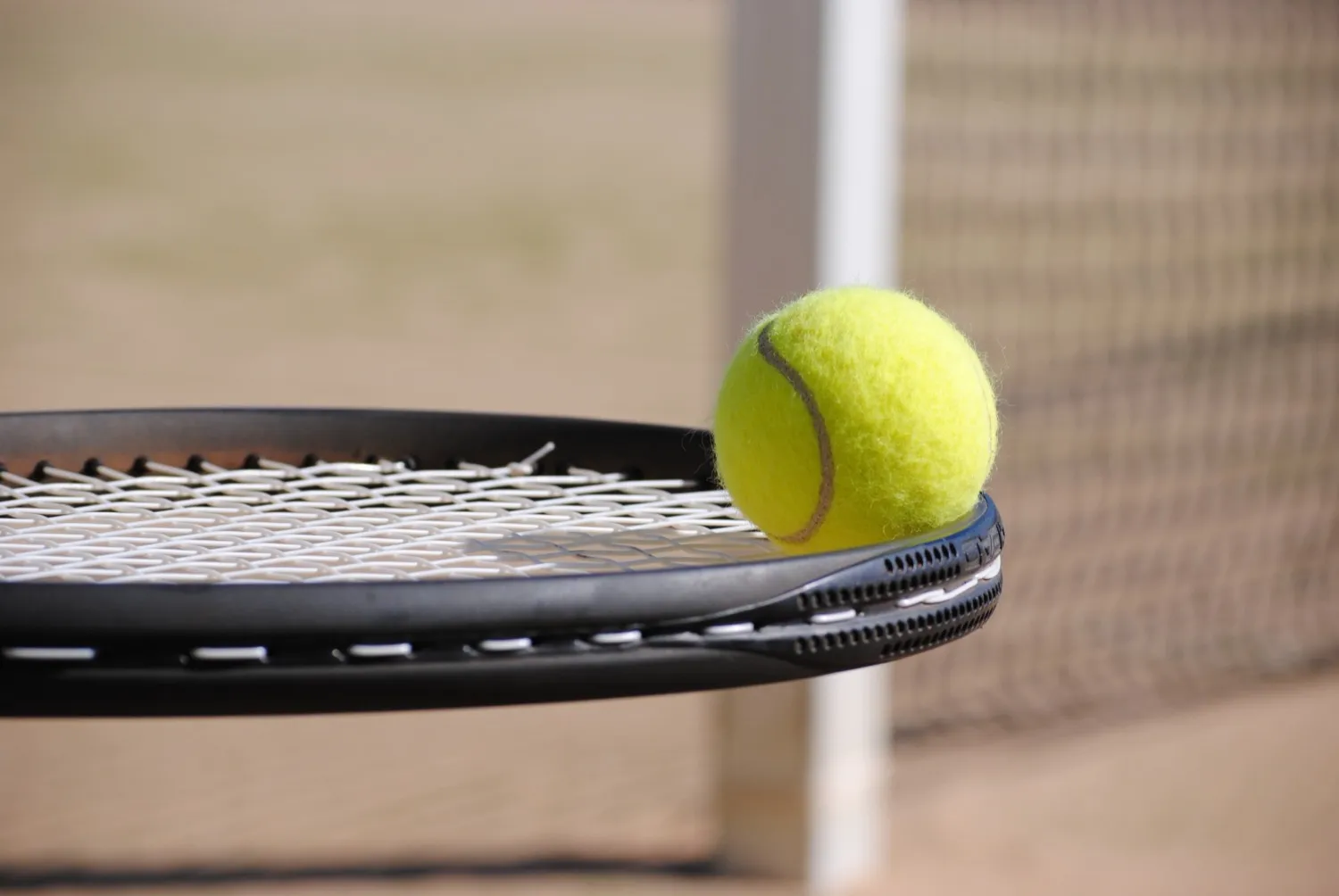 Tennisschläger mit Ball am Netz